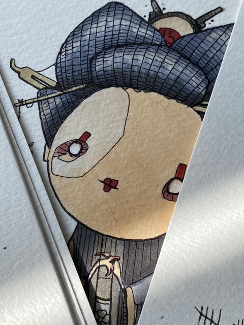Close-up of a pale doll-like face with red cheeks in a dark hood