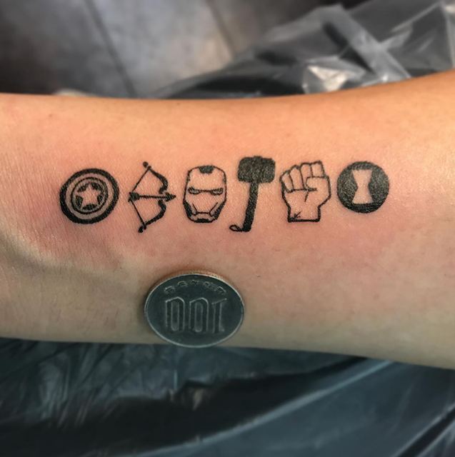 Extremely small Avengers logos tattoo by Deadpigeon (black & grey)